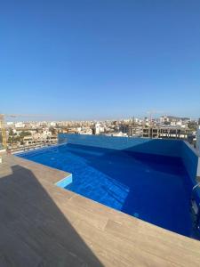 达喀尔Magnifique Appartement avec PISCINE, 3 Chambres, 4 Salles de Bain, Salle de Gym et Terrasse, LUXE ET COMFORT aux ALMADIES的建筑物屋顶上的蓝色游泳池