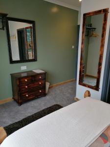 纽基Pensalda Guest House的一间卧室配有一张床、梳妆台和镜子
