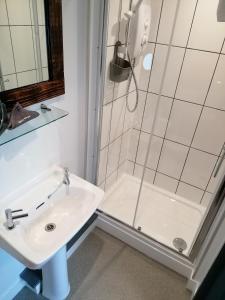 纽基Pensalda Guest House的带淋浴和盥洗盆的白色浴室