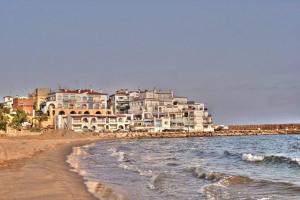 罗达德瓦拉Apartamento vacacional Roda de Barà的海浪与大海的海滩上的酒店