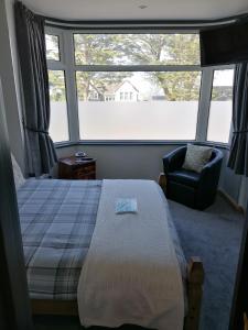 纽基Pensalda Guest House的卧室配有床、椅子和窗户。