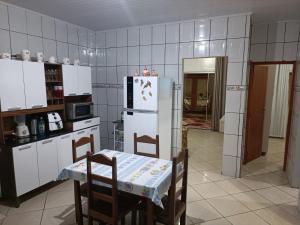 普拉杜Casa Temporada Prado-BA的厨房配有桌子和白色冰箱。