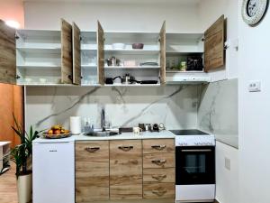 鲁马Stella Apartman Ruma的厨房配有白色家电和木制橱柜
