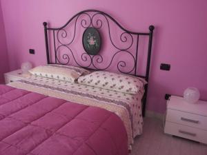 阿夸维瓦皮切纳B&B Il Giardino Mediterraneo的粉红色的卧室,配有一张床和粉红色的墙壁
