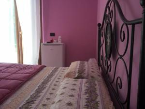 阿夸维瓦皮切纳B&B Il Giardino Mediterraneo的紫色客房内的一间卧室,配有一张床