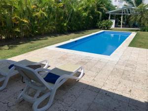 拉罗马纳Villa Real Playa Nueva Romana的几把椅子和一个游泳池