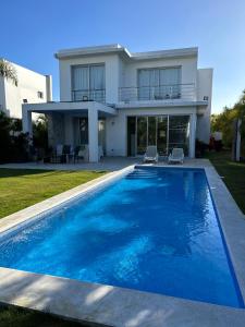 拉罗马纳Villa Real Playa Nueva Romana的房屋前有游泳池的房子
