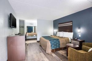 哈蒙顿Red Carpet Inn & Suites NJ-73的小酒店客房配有一张床和一张书桌