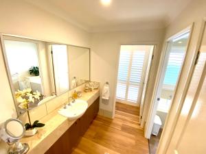 木麻黄Casuarina Beach 2 bedroom retreat的一间带水槽和大镜子的浴室