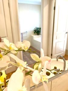 木麻黄Casuarina Beach 2 bedroom retreat的浴室设有镜子前白色花卉水槽