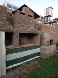 乌斯帕亚塔Departamento LA LILI的一座砖砌建筑,在院子里设有比萨饼烤箱