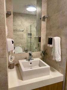纳苏格布1BD 1BA PENTHOUSE 2X QUEEN的浴室设有白色水槽和镜子
