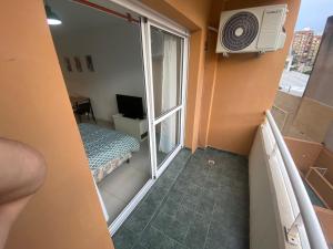 罗萨里奥Depto zona centro muy comodo.的小客房设有带一张床和窗户的阳台。
