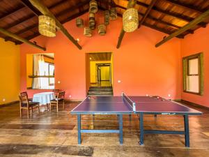 卡舒埃拉斯迪马卡库Hotel Fazenda Filhos do Vento的橙色墙壁的房间里设有乒乓球桌
