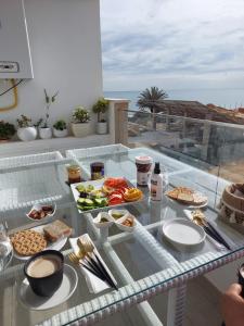 甘达坞伊港Appartement Residence Essayedi Sousse的阳台上桌子上的托盘食物