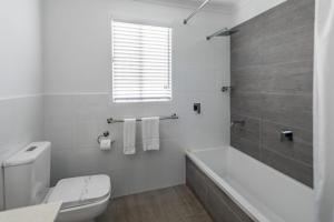 凯恩斯Ingenia Holidays Cairns Coconut的白色的浴室设有浴缸和卫生间。