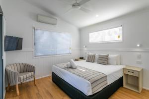 凯恩斯Ingenia Holidays Cairns Coconut的白色卧室配有床和椅子