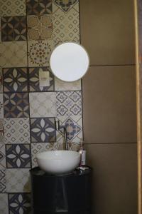 圣若昂-巴蒂斯塔-杜格罗里亚Casa de Roça的浴室设有水槽、灯和瓷砖