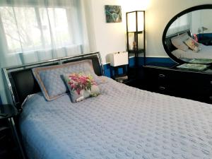 华盛顿华盛顿私人度假公寓的一间卧室配有一张带镜子和鲜花的床
