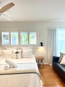 拜伦湾拜伦湾海滩棚子别墅的一间卧室配有一张大床和一张蓝色的沙发
