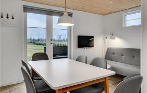 博托比2 Bedroom Nice Apartment In Vggerlse的一间配备有白色桌椅的用餐室