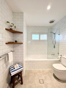 拜伦湾拜伦湾海滩棚子别墅的带浴缸、卫生间和盥洗盆的浴室