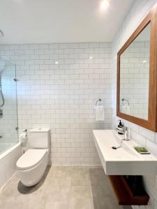拜伦湾拜伦湾海滩棚子别墅的一间带卫生间、水槽和镜子的浴室