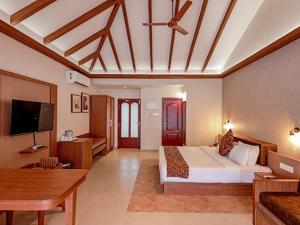 马拉利库兰阿巴德龟背湾泳滩酒店的配有一张床和一台平面电视的酒店客房