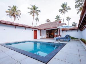 马拉利库兰阿巴德龟背湾泳滩酒店的棕榈树屋前的游泳池