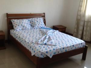 圣多美E格拉瓦那公寓的一张带蓝色和白色床单及枕头的床
