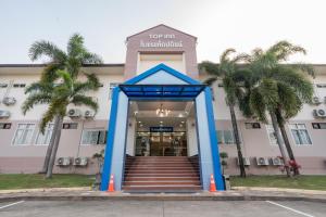 玛哈沙拉堪TOP INN โรงแรมท็อปอินน์的享有棕榈树建筑的正面景色