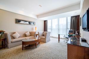 镇江镇江兆和皇冠假日酒店的客厅配有沙发和桌子