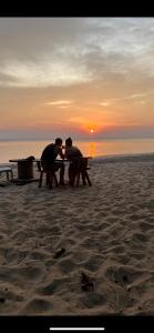 俊穆岛俊穆岛阳光微笑海滩旅馆的两人坐在海滩上的野餐桌上
