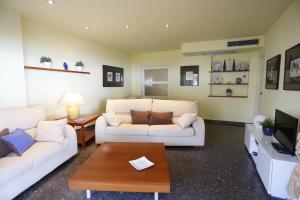 坎布里尔斯Apartamentos Alquihouse Vilafortuny的客厅配有2张白色沙发和1张咖啡桌