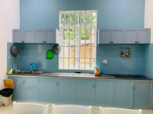 保禄Mon House的蓝色的厨房,配有水槽和窗户