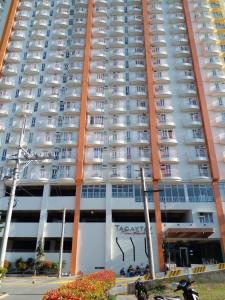 大雅台Tagaytay Prime Residences with Swimming Pool & Viewing Deck的一座大型公寓楼,上面有绘画作品