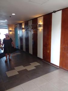 大雅台Tagaytay Prime Residences with Swimming Pool & Viewing Deck的走下大楼走廊的女人