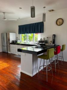 宾南邦LUMUN Holiday Home Rental的一个带柜台和椅子的厨房