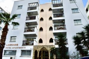 尼科西亚尼科西亚罗德斯公寓式酒店的带阳台的白色建筑,棕榈树