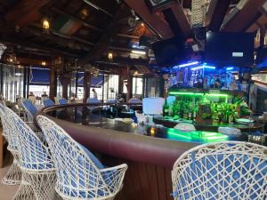 奥隆阿波PALM TREE RESORT AND RESTAURANT的餐厅内的酒吧,配有椅子和吧台