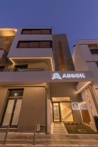 沃洛斯Aeson Premium Living的建筑的侧面有阿柯亚标志