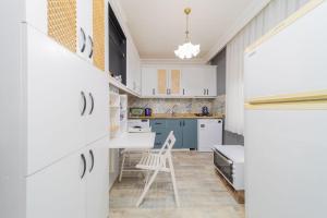 安塔利亚Stylish Flat with Modern Design in Antalya的厨房配有白色橱柜和椅子