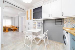 安塔利亚Stylish Flat with Modern Design in Antalya的厨房以及带桌椅的起居室。