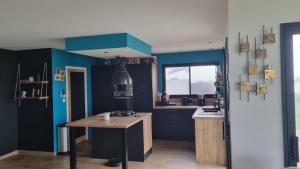 PlouarzelMaison 3 chambres vue mer et phare的厨房设有蓝色的墙壁和木桌