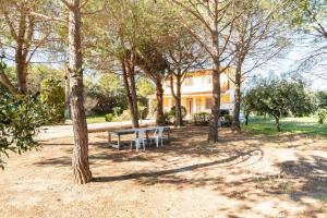 阿沃拉Villa Gioia Relais的房屋前有长凳和树木的公园