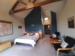 新普利茅斯Taranaki Country Lodge的一间卧室配有一张床和两把椅子