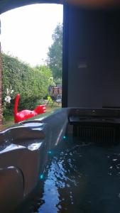 GommegniesAu repos de la licorne的院子里的带红色椅子的水池