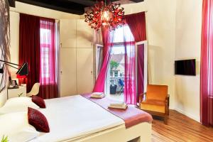 萨格勒布艺术风格酒店的一间卧室配有一张大床和一个吊灯。