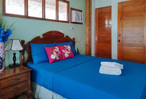伊洛伊洛Casa Nena Hotel & Resort Iloilo by RedDoorz的一间卧室配有一张蓝色的床和木制床头板