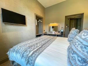 格拉斯米尔格拉斯米尔盛大酒店的卧室配有一张床铺,墙上配有电视